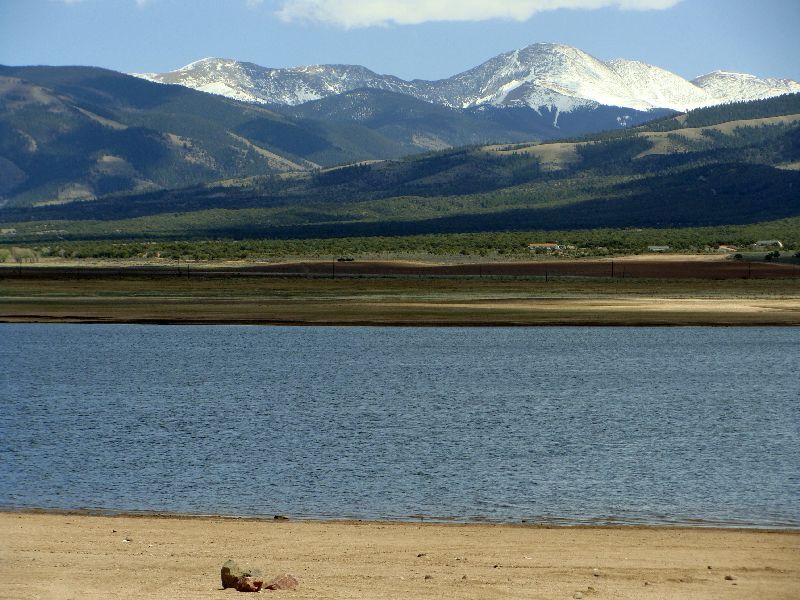 Mountain Home Reservoir near Fort Garland Colorado with sandy beach, blue water, and snow-capped Culebra Peak (a 14,047-foot fourteener) in the background — fishing, camping, and boating destination accessible to Sangre de Cristo Ranches landowners